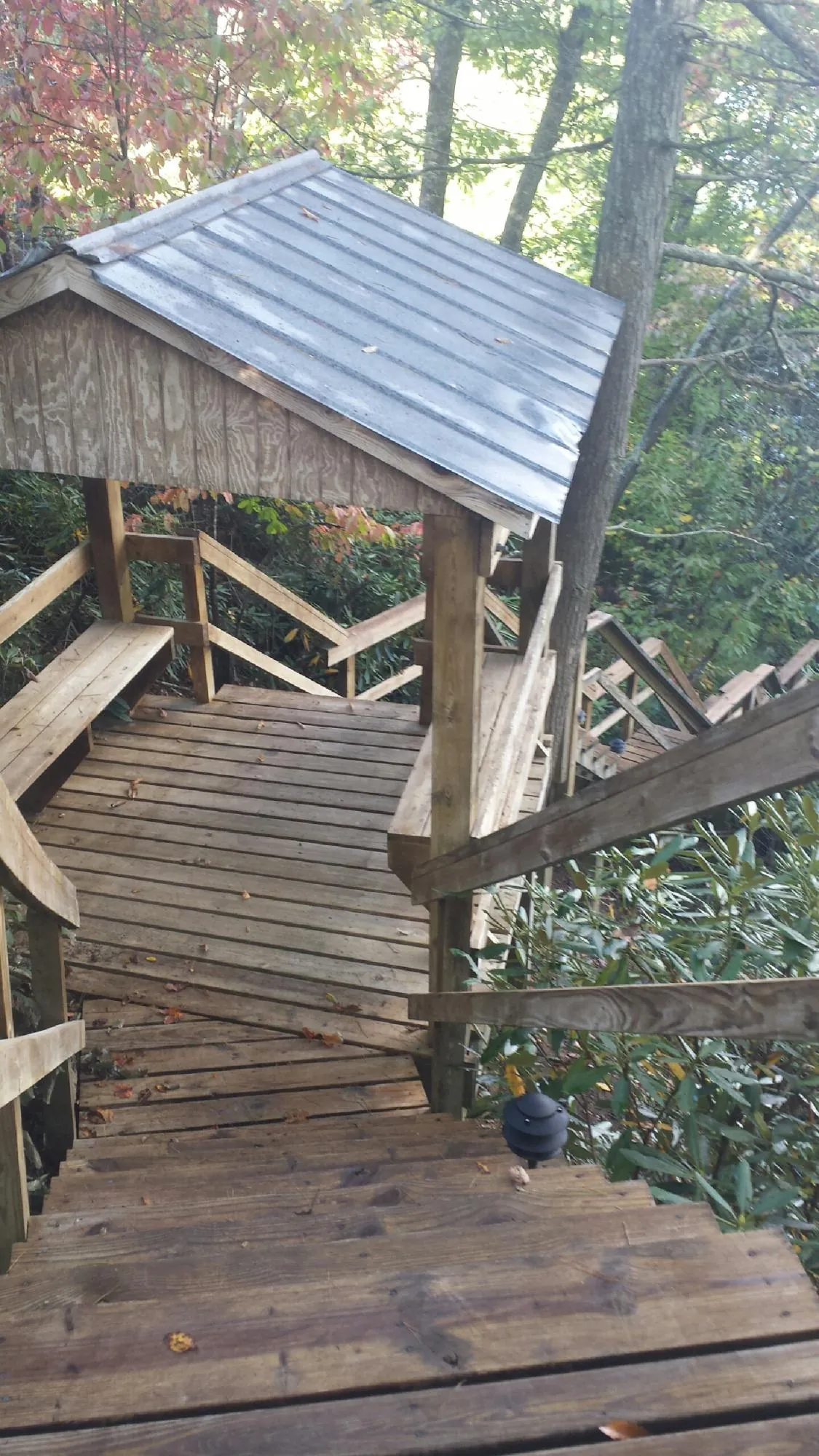 Metal roofed shelter over wooden steps on a wooded walkway — Skylight Repair & Installation work by our crew in Holbrook