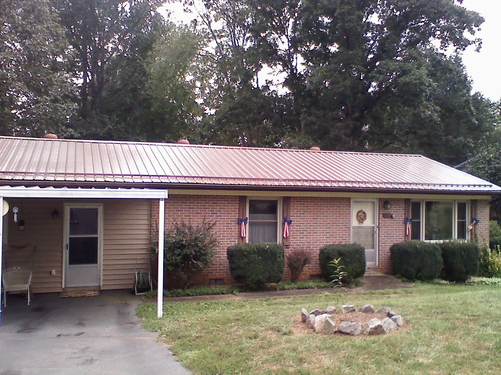 Bronze metal roof and carport on a brick ranch home — Roof Repair work by our crew in Holbrook